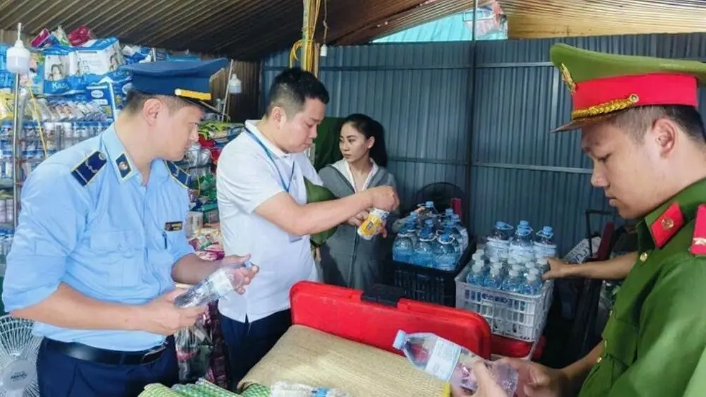Phát hiện người phụ nữ tự rót nước vào chai mang nhãn hiệu nổi tiếng để bán, lực lượng chức năng kiểm tra và thu giữ hàng hóa liên quan.