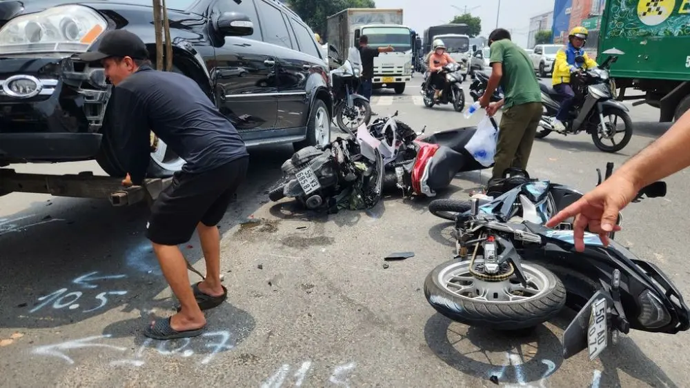 Ôtô Mercedes tông 3 xe máy dừng đèn đỏ ở TP HCM, khiến hai người bị thương và nhiều xe hư hỏng sau vụ tai nạn liên hoàn.