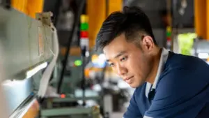 Anh Huy kiểm tra máy dệt công suất cao tại xưởng lụa Nha Xá, nơi công nghệ giúp tăng năng suất và giảm phụ thuộc vào sức người.